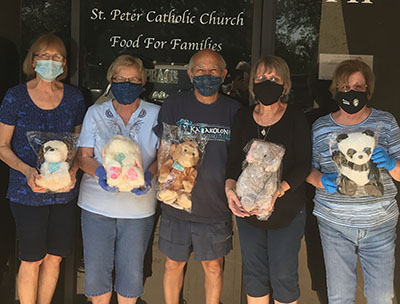 Food For Families team posing with little hugs stuffed animals