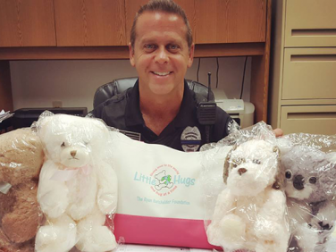 delray beach police office with little hugs donated