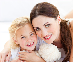 woman with brown hair and girl with blonde hair and white teddy bear