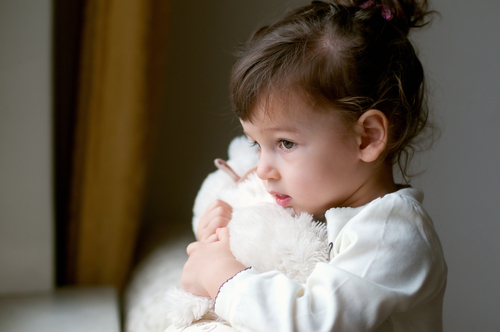 toddler hugging white teddy bear