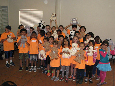 Camp Stingray children holding their new little hugs donated plushies