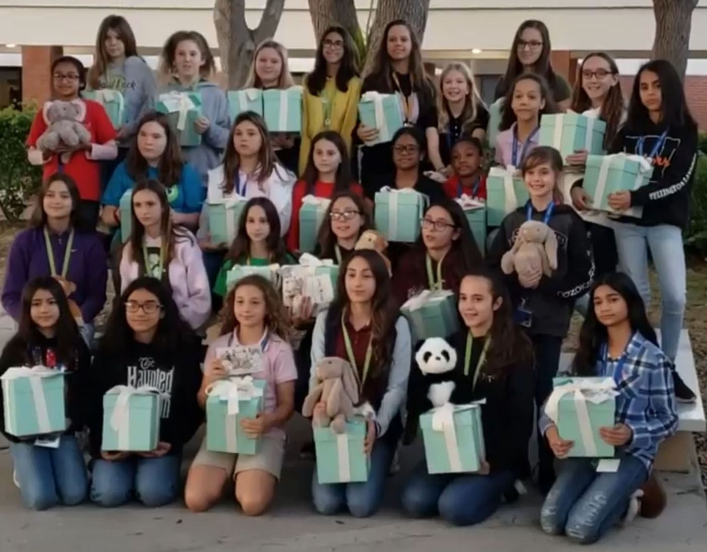 Kindness Club posing for picture with little hugs stuffed animals